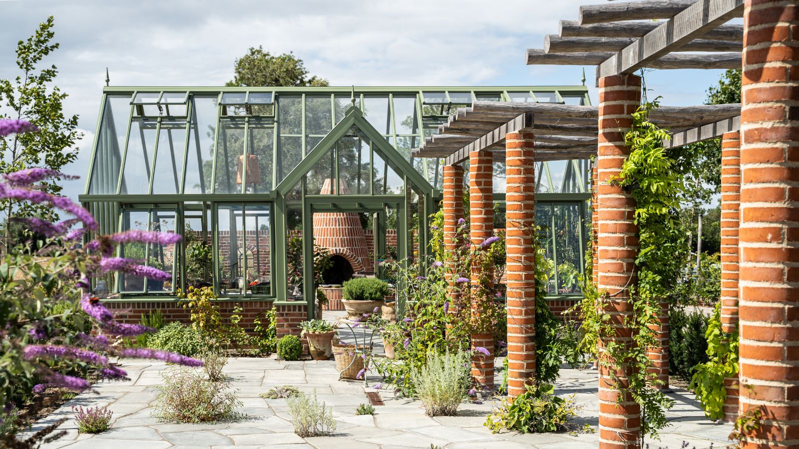 Glass gardens bespoke 1 Oranjerie cu ramă verde lângă o pergolă din cărămidă