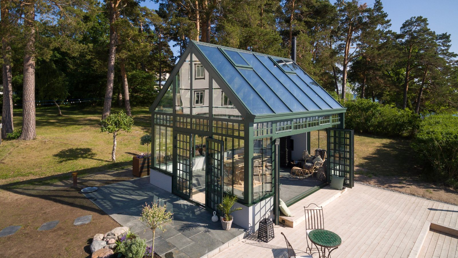 Glass gardens bespoke 5 Oranjerie cu ramă închisă printre pini, cu terasă din lemn