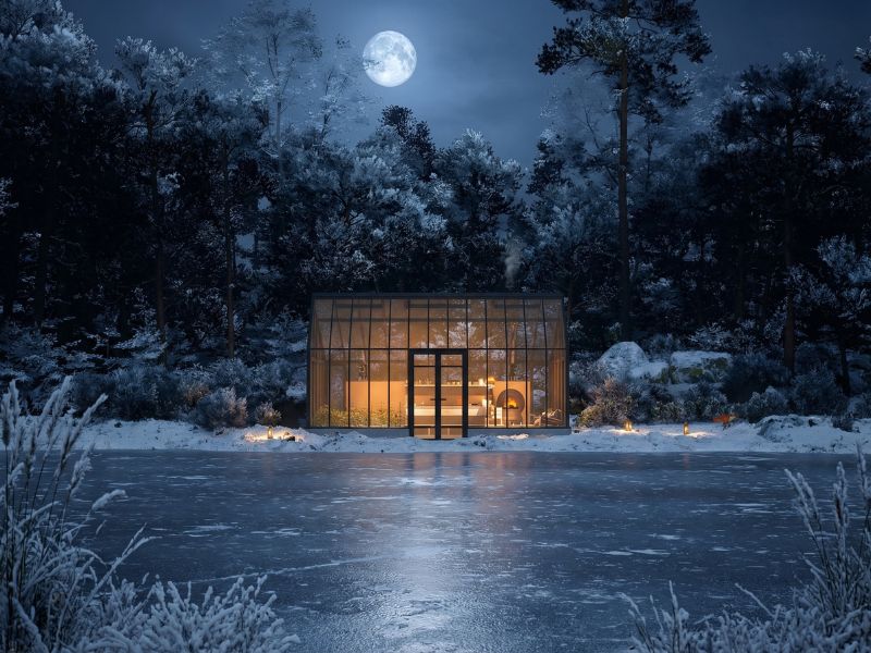 Oranjerie Sanctuary Max luminată noaptea pe malul unui lac înghețat, sub lună plină